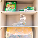 Streetwear display with collectible green sneaker, futuristic Nike MAG shoe, designer bag, and retro sign