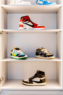 Streetwear sneaker collection displayed on white shelves, featuring colorful and high-top sneakers.