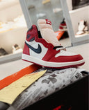 Red, white, and black high-top sneaker displayed on shoebox in modern sneaker store