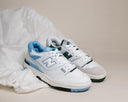 Two New Balance 550 sneakers in blue and green colorways on neutral background