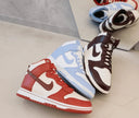 Assorted Nike Dunk high-top sneakers in red, blue, and brown colorways on a concrete floor