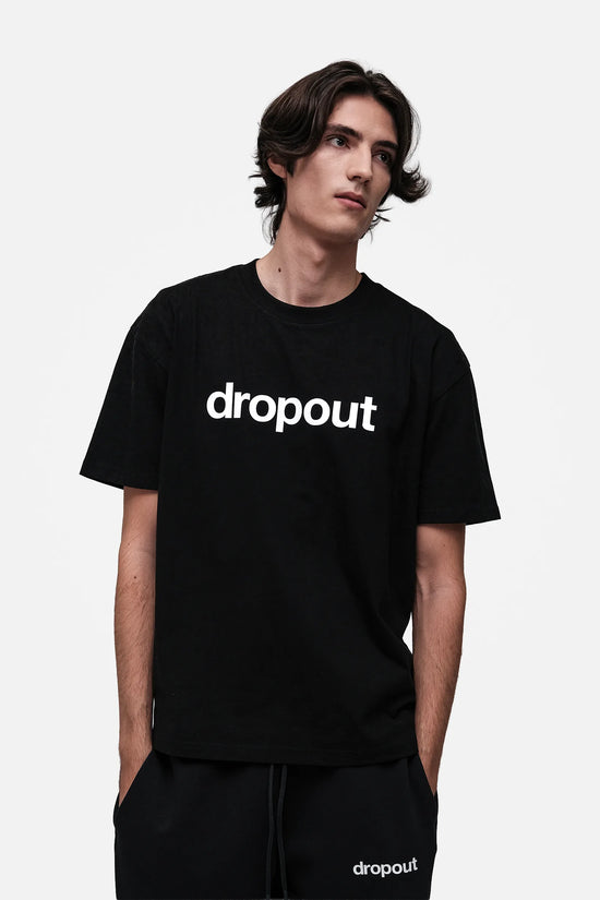Person wearing a black 'dropout' t-shirt on a white background