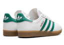 White Adidas Gazelle sneakers with green accents on a white background
