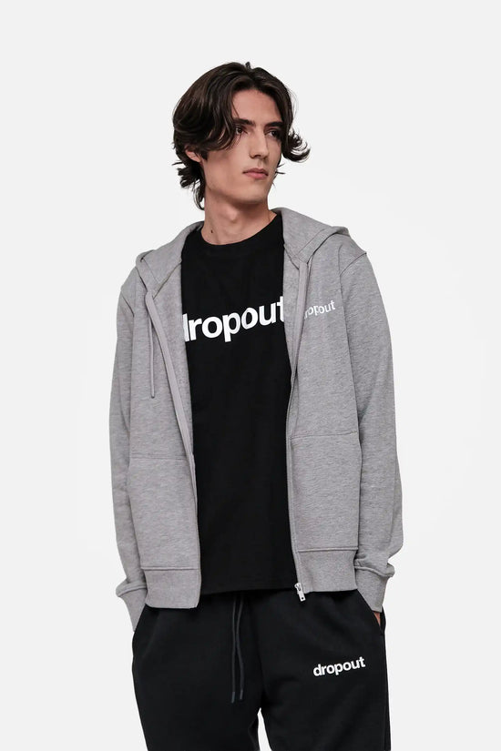 Person wearing a grey hoodie, black t-shirt, and black pants with 'dropout' branding on a light grey background