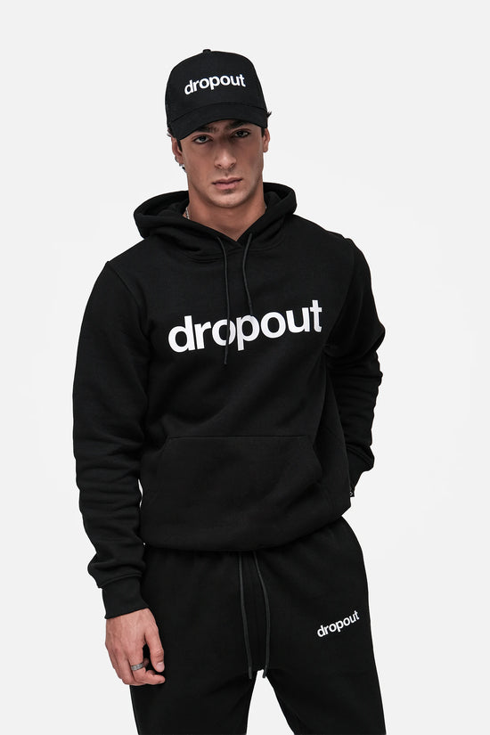 Person wearing a black 'dropout' hoodie and cap on a white background