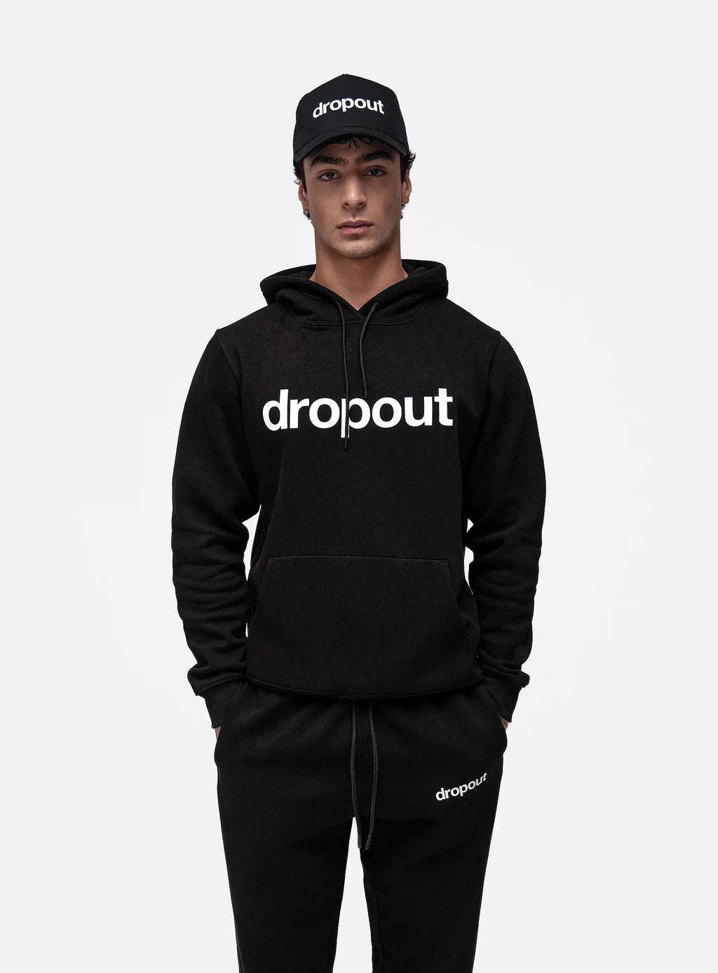 Model in black dropout Milano hoodie, sweatpants, and cap, premium streetwear ensemble