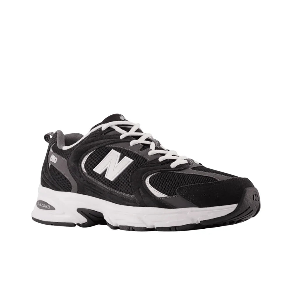 Black and white New Balance sneaker with mesh and suede details, side profile view