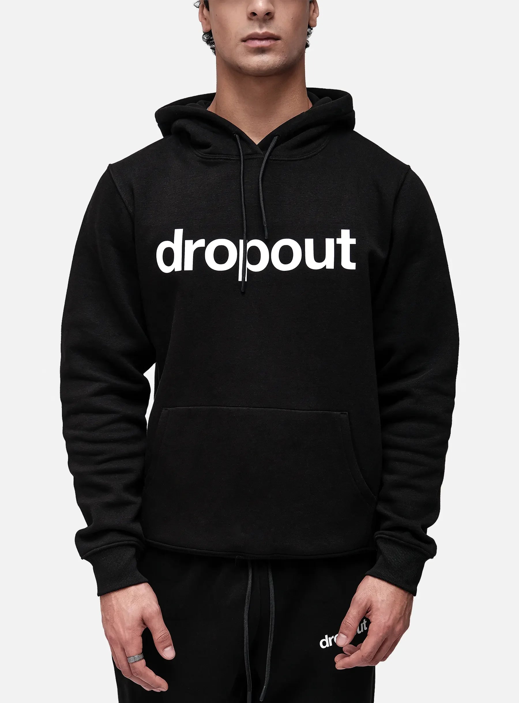 Person wearing a black hoodie with 'dropout' text on a white background