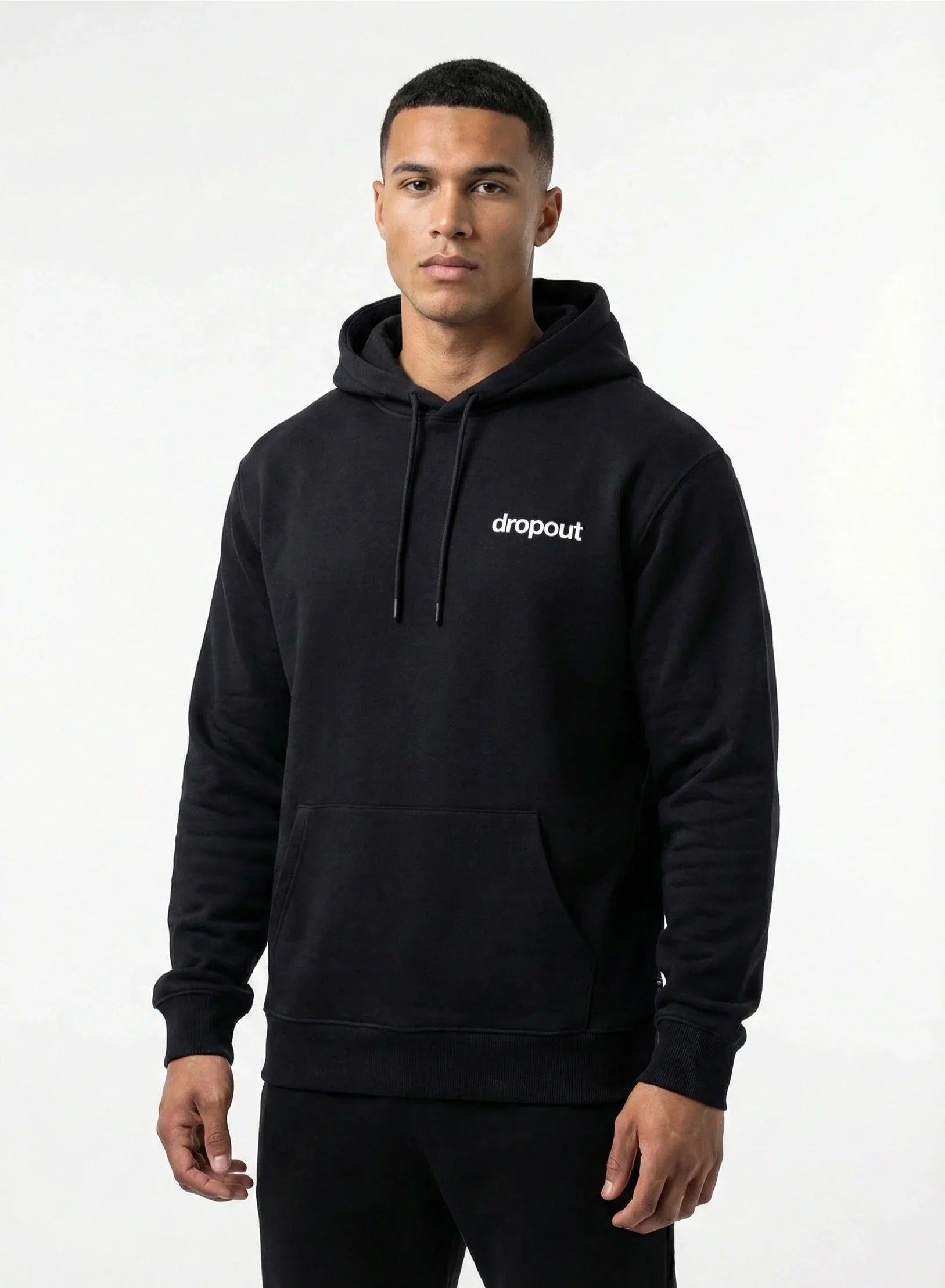 Man wearing a black hoodie with 'dropout' logo on a white background
