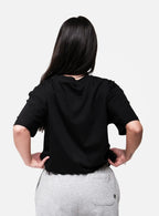 Person wearing a black oversized t-shirt and gray pants on a white background
