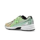 Side view of a green and beige mesh streetwear sneaker with chunky white sole