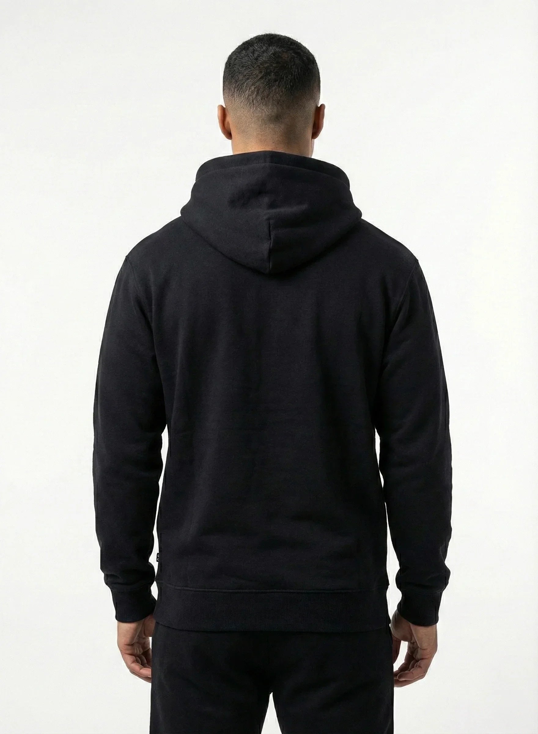 Person wearing a black hoodie from behind on a white background
