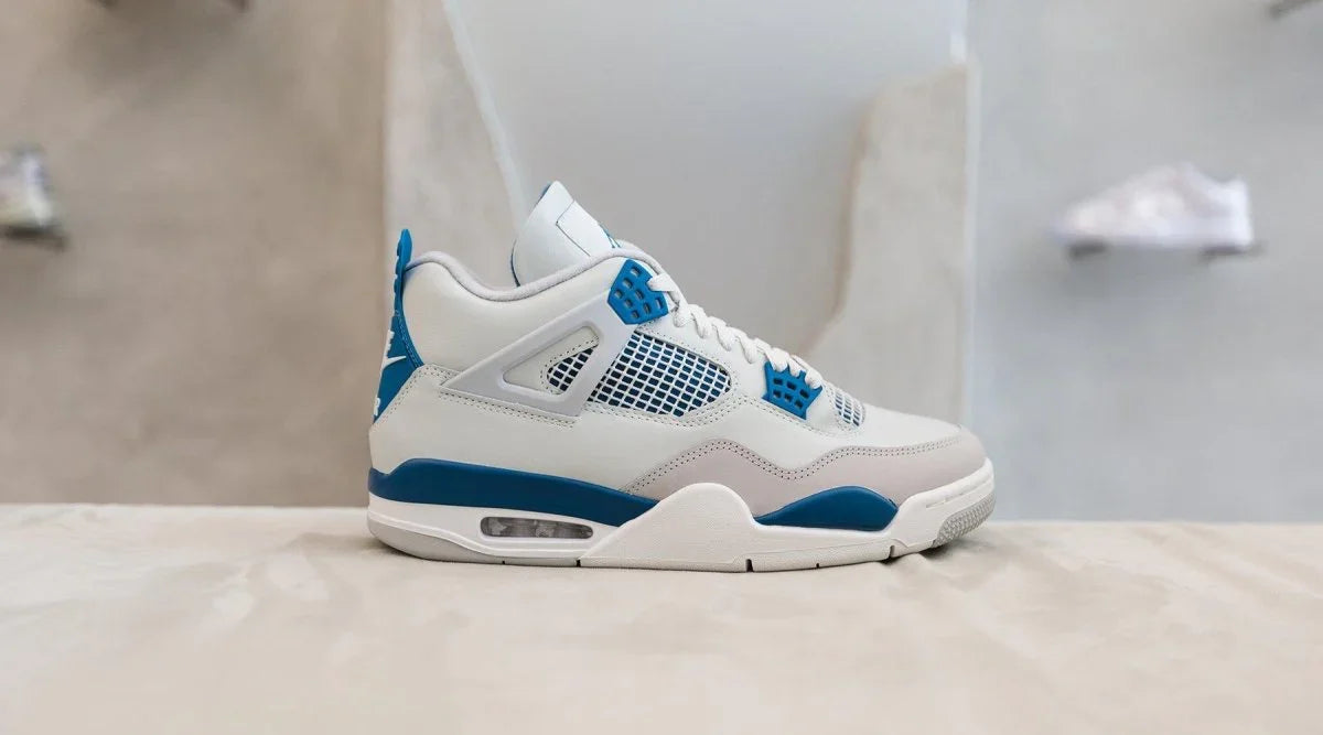 White and blue streetwear sneaker with mesh side panel on a light surface, side view