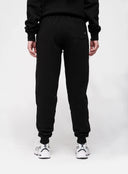 Person wearing black sweatpants on a white background