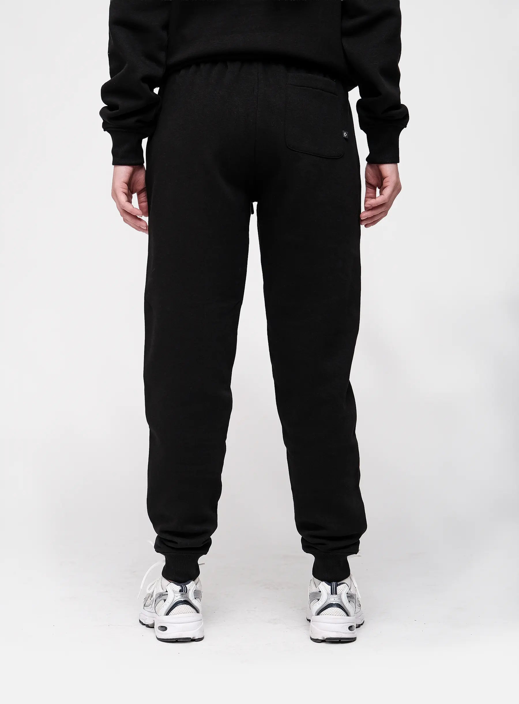 Person wearing black sweatpants on a white background