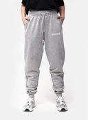 Person wearing grey sweatpants with 'dropout' logo on a white background