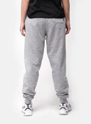 Person wearing grey sweatpants on a white background