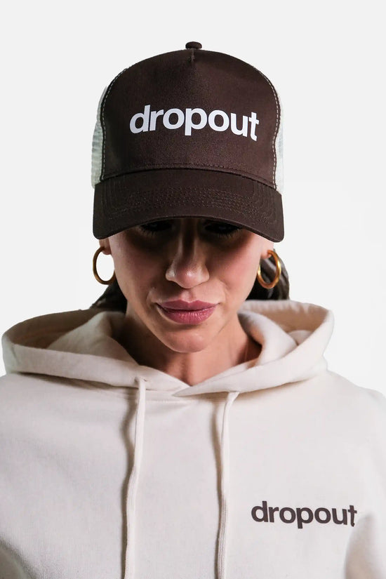 Person wearing a Brown/Beige 'dropout' cap and white hoodie with 'dropout' logo.