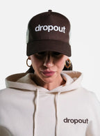 Person wearing a Brown/Beige 'dropout' cap and white hoodie with 'dropout' logo.