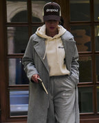 Person wearing a Beige hoodie, and gray pants with 'dropout' branding.