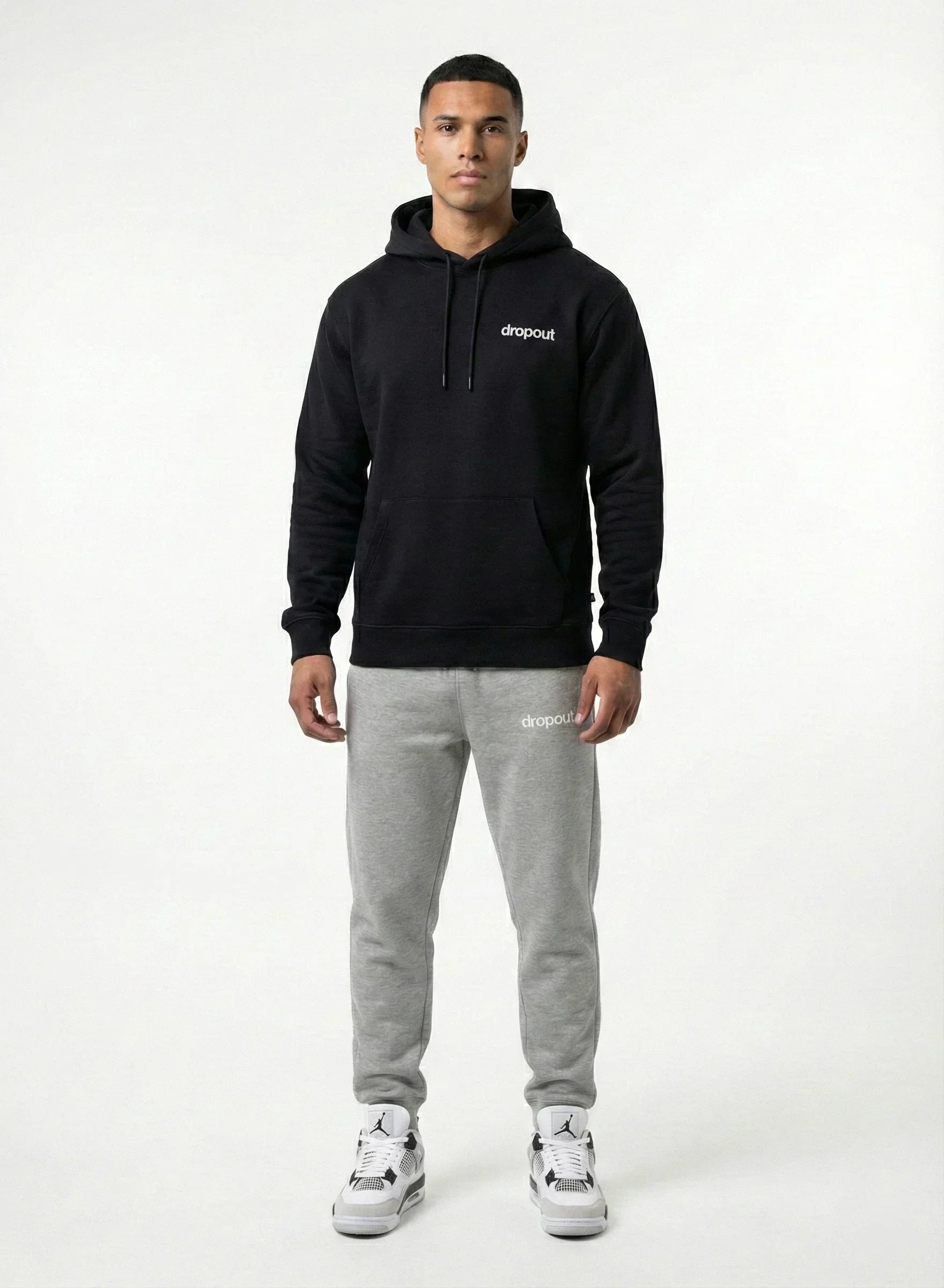 Man wearing a black hoodie and gray sweatpants with a brand logo on a white background