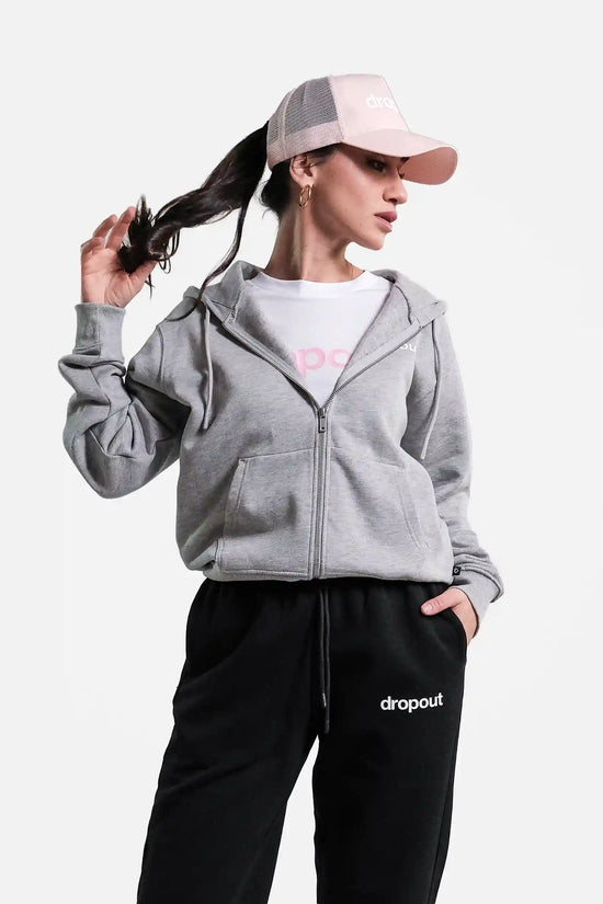 Person wearing a grey hoodie and black pants with 'dropout' branding on a white background