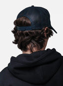 Person wearing a black hoodie and White/Navy cap from behind on a white background