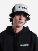 Person wearing a black hoodie and White/Navy cap with 'dropout' branding on a gray background