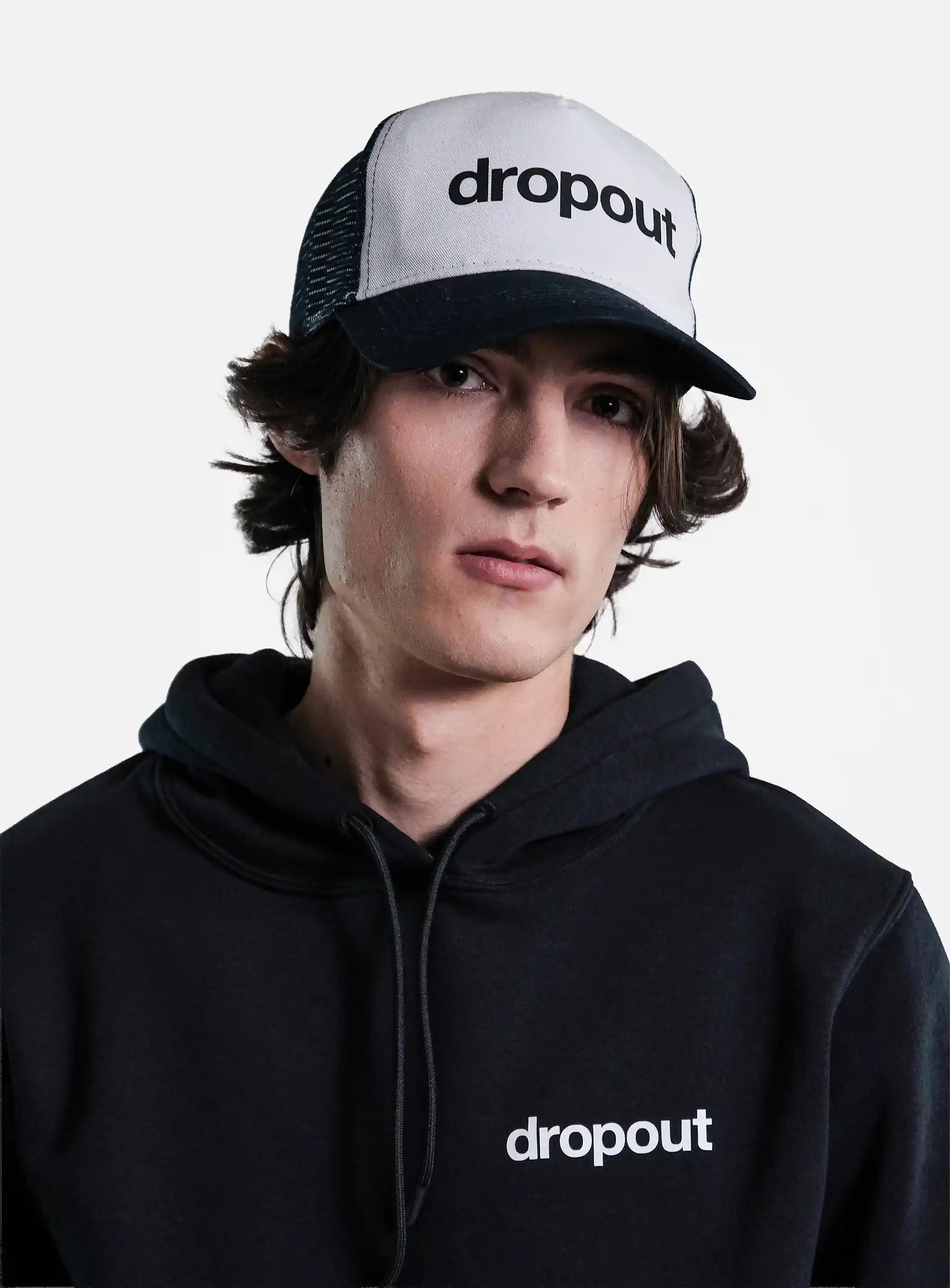 Person wearing a black hoodie and White/Navy cap with 'dropout' branding on a gray background