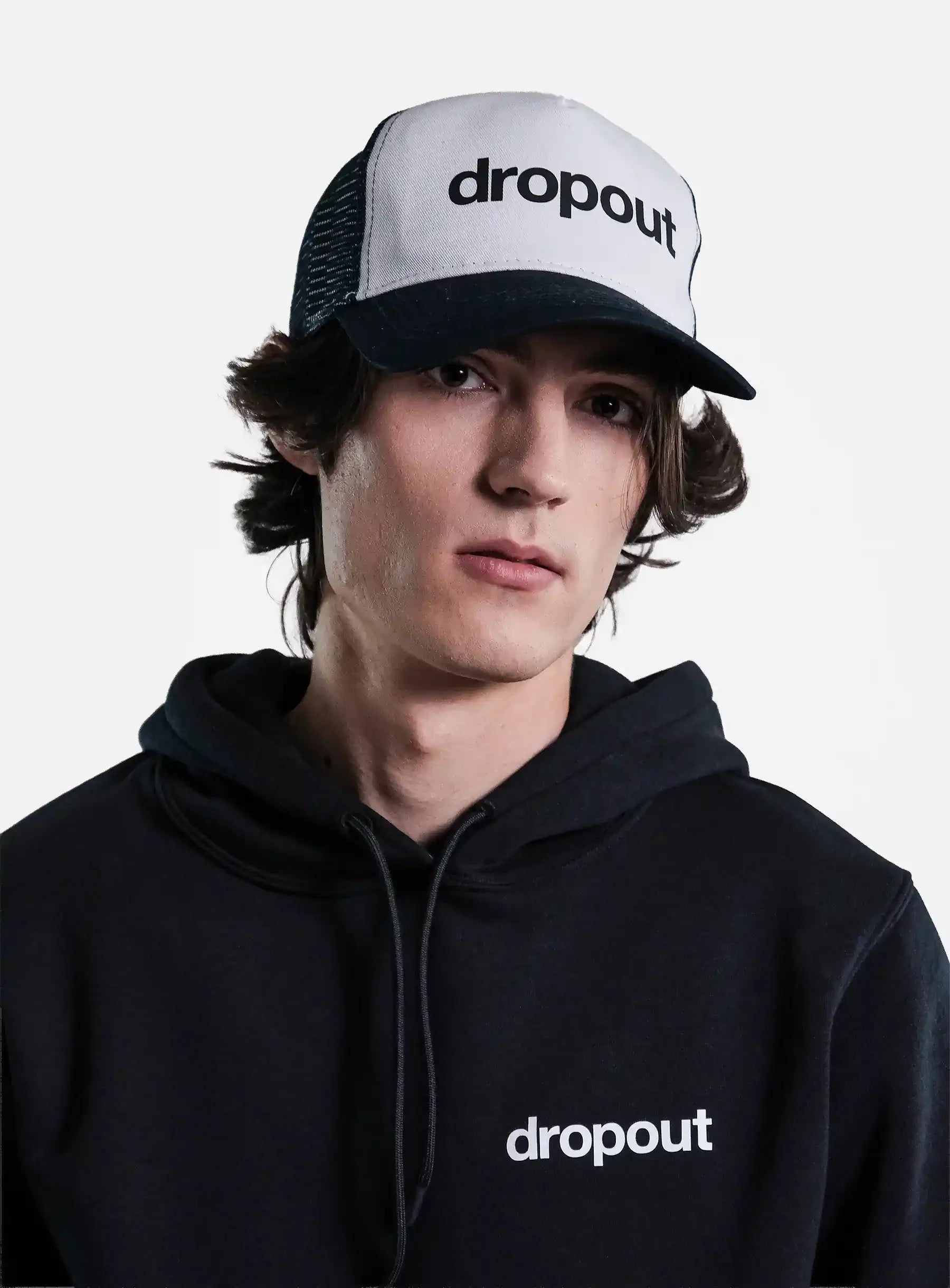 Person wearing a black hoodie and White/Navy cap with 'dropout' branding on a gray background
