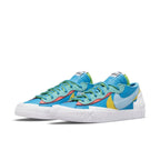 Nike Blazer Low sacai KAWS Neptune Blue sneakers with vibrant blue, yellow, and white details.