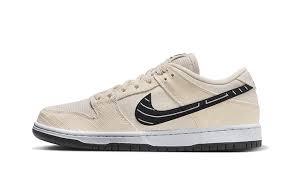 Nike SB Dunk Low Albino & Preto in light tan fabric with black swoosh and pearl weave texture.